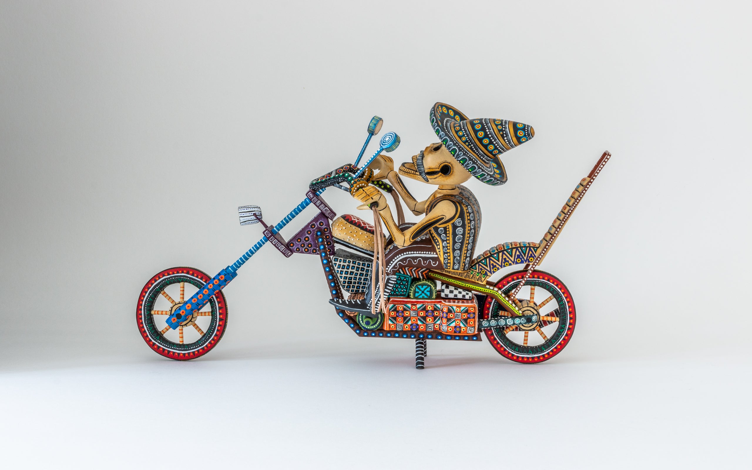 Motorrad mit bunten Mustern bemalt, der Fahrer ist eine männliche Catrina - am Día de Muertos.
