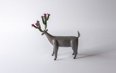 Grau bemalter Hirsch mit Kaktus-Geweih, Sicht von hinten.