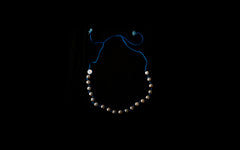 Halskette mit Silberkugeln auf blauer Seidenkordel..
