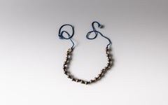 Halskette auf blauer Seidenkordel mit Silberkugeln.